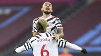 Pemain Manchester United, Paul Pogba, melakukan selebrasi bersama Alex Telles usai mencetak gol ke gawang West Ham United pada laga Liga Inggris di Stadion London, Minggu (6/12/2020). Setan Merah menang dengan skor 1-3. (Justin Setterfield/Pool Via AP)