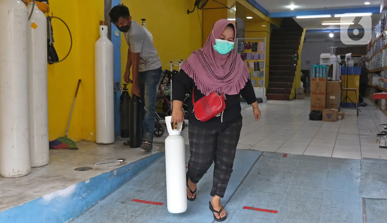 Warga berjalan keluar usai mengisi ulang oksigen di Fauzi Medical, Matraman, Jakarta Timur, Kamis (22/7/2021). Sebagai bentuk kepedulian terhadap sesama di tengah pandemi COVID-19, agen isi ulang oksigen tersebut menerapkan sistem pembayaran secara sukarela bagi warga. (Liputan6.com/Herman Zakharia)