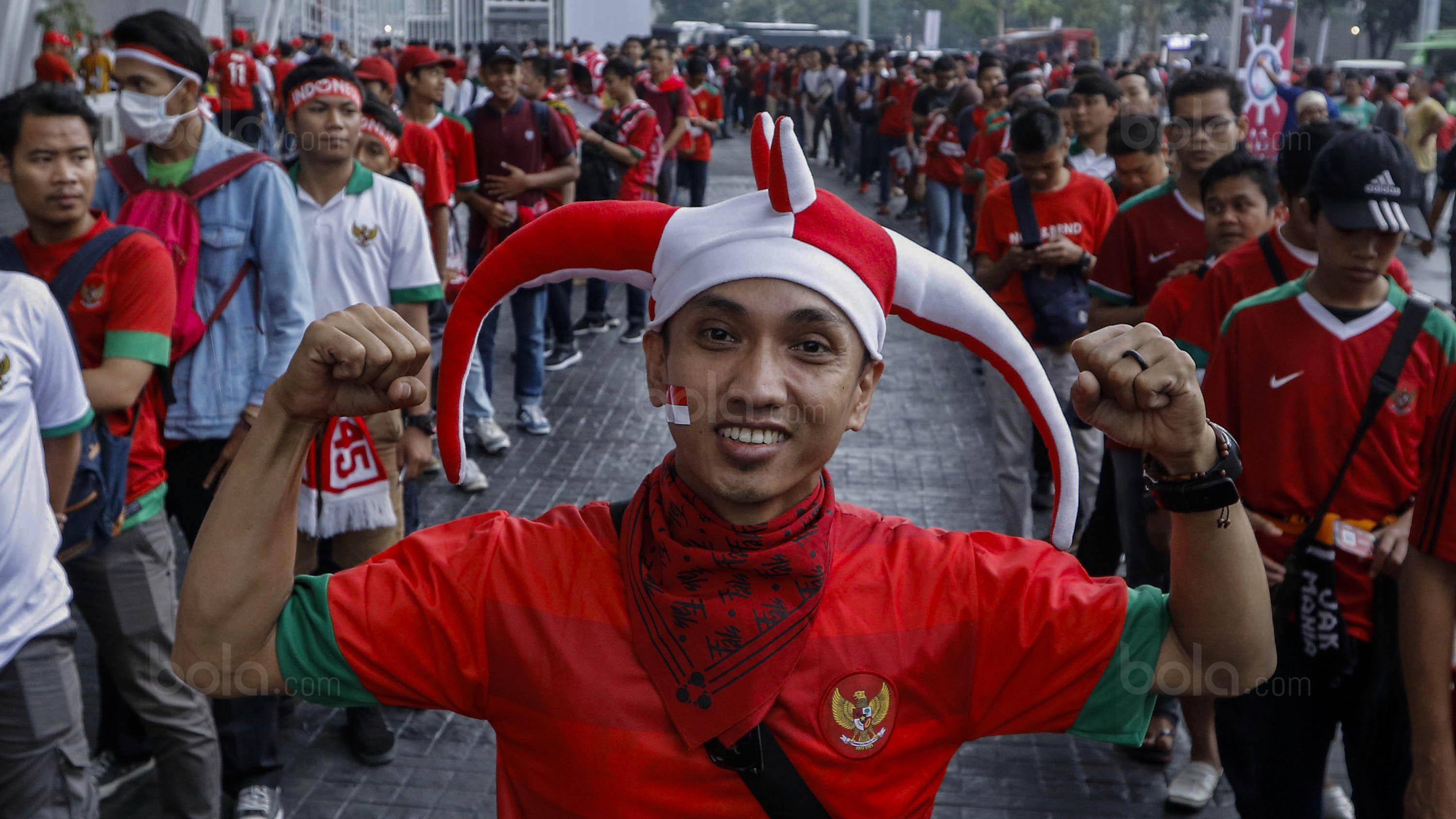 Seorang suporter bersiap menyaksikan laga persahabatan antara Timnas Indonesia melawan Islandia di Stadion Utama Gelora Bung Karno, Jakarta, Minggu (14/1/2018). Timnas Indonesia kalah 1-4 dari Islandia. (Bola.com/M Iqbal Ichsan)