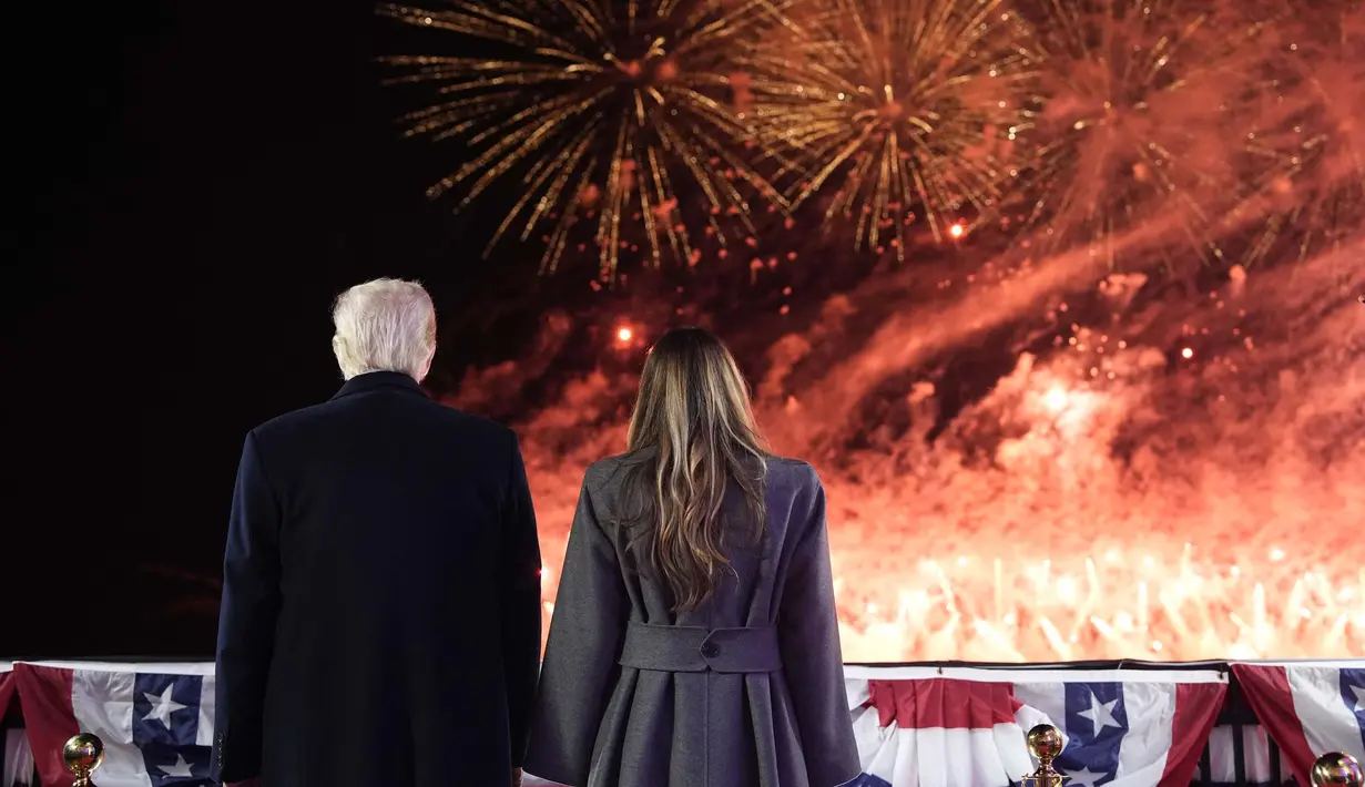 Presiden terpilih Amerika Serikat (AS) Donald Trump dan istrinya Melania Trump menyaksikan kembang api saat resepsi di Trump National Golf Club Washington DC, Sterling, Virginia, pada 18 Januari 2025. (Alex Brandon/POOL/AFP)