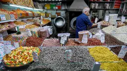 Pedagang memajang kacang-kacangan dagangannya saat berjualan di sebuah pasar di Ibu Kota Damaskus, Suriah, Minggu (19/5/2019). Perang sipil yang berlangsung selama delapan tahun terakhir membuat warga Suriah harus berhemat saat Ramadan. (Louai Beshara/AFP)