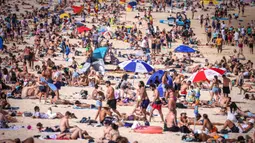 Orang-orang mengunjungi pantai Bondi di Sydney, Australia pada 5 Oktober 2020. Pengunjung ramai berjemur dan bermain di pantai dan berenang di laut saat pandemi Covid-19 masih berlangsung.  (Photo by DAVID GRAY / AFP)