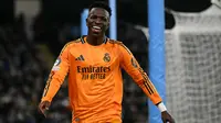 Pemain Real Madrid, Vinicius Junior tertawa saat laga leg 1 babak playoff Liga Champions 2024/2025 melawan Manchester City di Etihad Stadium, Manchester, Inggris, Rabu (12/02/2025) WIB. (AFP/Oli Scarff)