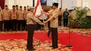 Presiden Joko Widodo (kanan) memberikan bendera Merah Putih kepada Kontingen Gerakan Pramuka Indonesia saat upacara pelepasan di Istana Negara, Jakarta, Jumat (19/7/2019). Pramuka Indonesia akan terbang ke Virginia Barat untuk menghadiri Jambore Pramuka Dunia XXIV. (Liputan6.com/Angga Yuniar)