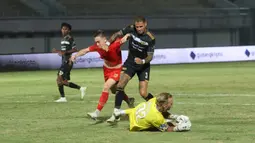 Kiper Dewa United, Sonny Stevens berhasil menangkap bola dari ancaman pemain Persija Jakarta, Maciej Gajos (kiri) yang dikawal ketat Junior Eldstal pada laga pekan ke-10 BRI Liga 1 2023/2024 di Stadion Indomilk Arena, Tangerang, Jumat (25/8/2023). (Bola.com/M Iqbal Ichsan)