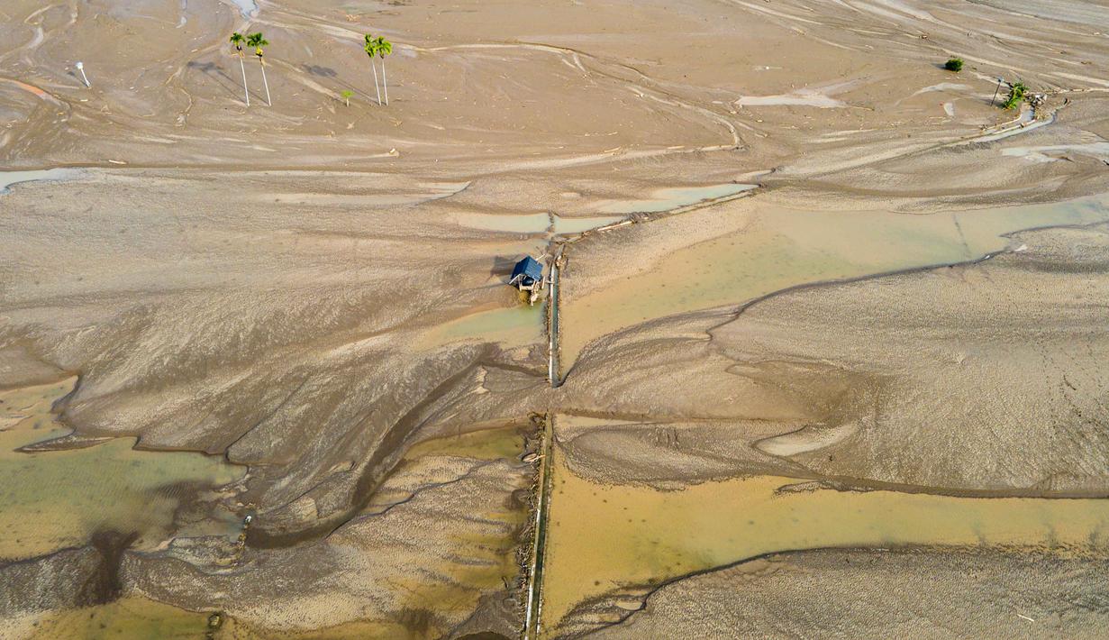 Kerusakan lahan pertanian ini berimbas pada gagal panen skala besar yang mengancam ketersediaan pangan lokal dan bahkan bisa berdampak pada harga pangan di wilayah yang lebih luas. Tampak foto pemandangan udara menunjukkan sawah yang terendam lumpur setelah banjir bandang di Meureudu, Kabupaten Pidie Jaya, Provinsi Aceh, pada Senin 8 Desember 2025. (Chaideer MAHYUDDIN/AFP)