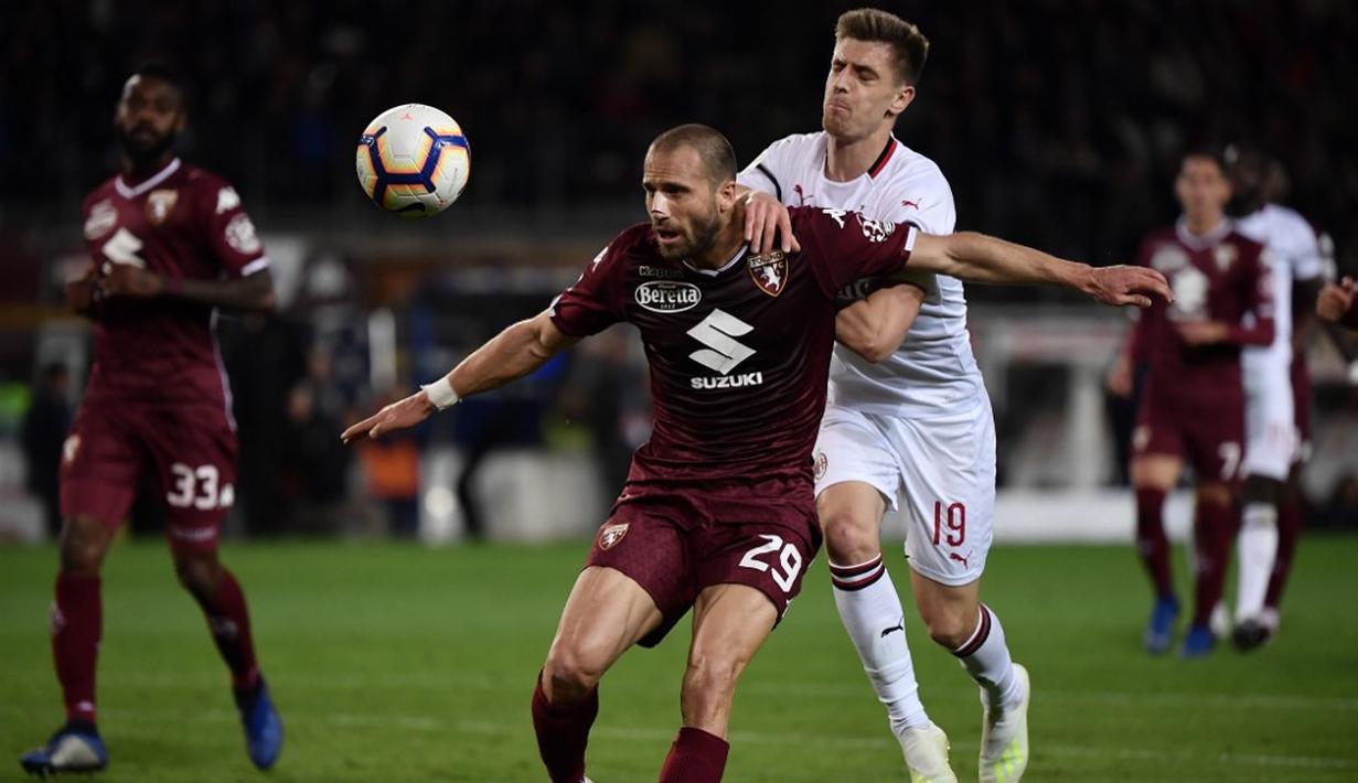 Duel antara De Silvesri dan Piatek pada laga lanjutan Serie A yang berlangsung di Stadion Turin, Torino, Senin (30/4). AC Milan kalah 0-2 kontra Torino. (AFP/Marco Bertorello)