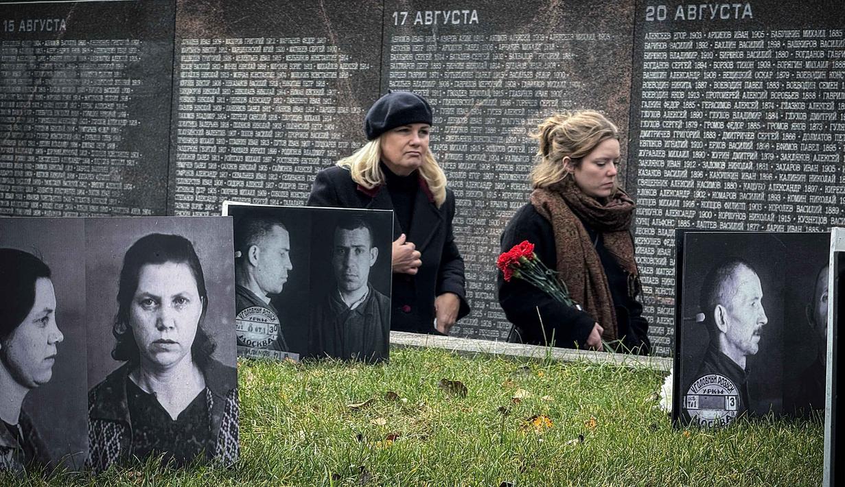 Orang-orang mengunjungi tugu peringatan bagi para korban represi politik di Butovo, di luar Moskow, pada Kamis 30 Oktober 2025, menandai hari peringatan. Peringatan ini sebagai pengingat akan kejahatan rezim Soviet dan penghormatan bagi para korban tewas dalam teror politik. Acara peringatan ini melibatkan keluarga dan kerabat korban yang berziarah ke lokasi tersebut. (Nikita BORISSOV/AFP)