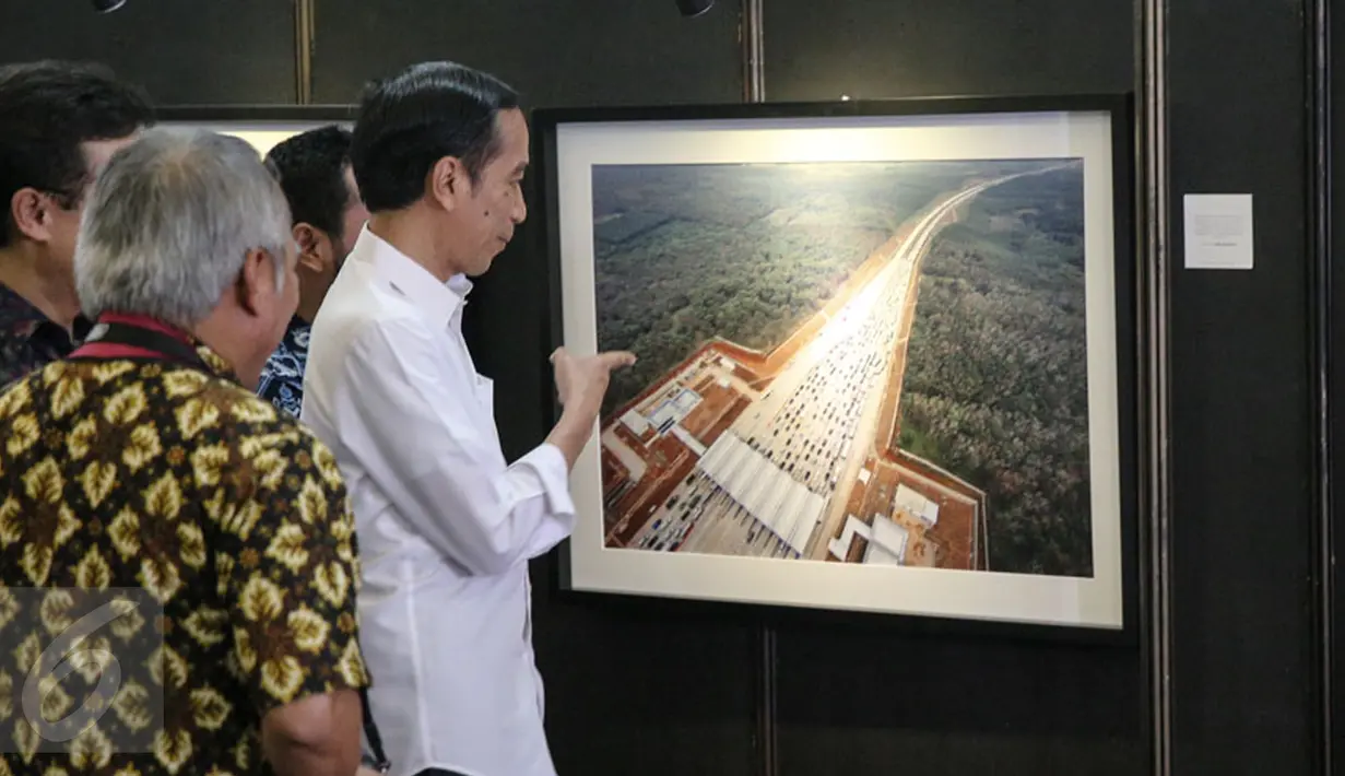 Presiden Joko Widodo melihat karya foto yang dipajang pada pameran foto jurnalistik Setahun Kerja Jokowi-JK di Museum Bank Mandiri, Jakarta, Jumat (18/12). Foto tersebut merupakan karya para anggota Pewarta Foto Indonesia (Liputan6.com/Faizal Fanani)