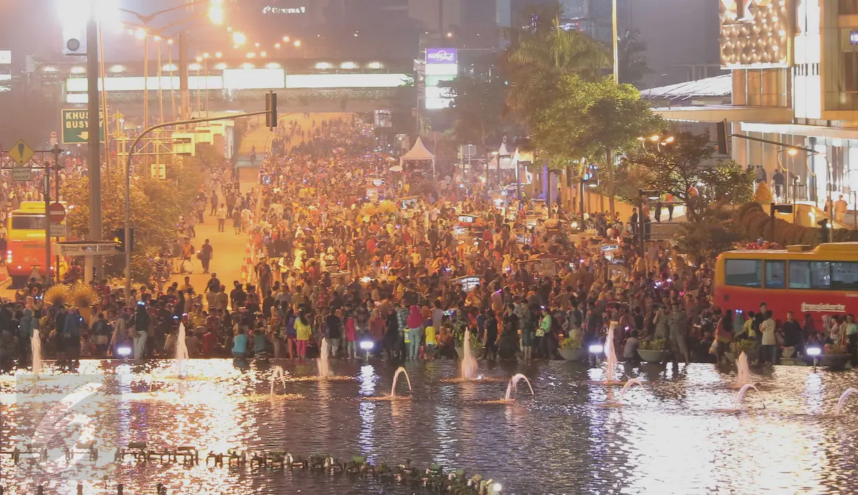 Warga memadati kawasan Bundaran HI, Jakarta, Kamis (31/12). Ribuan warga berkumpul untuk menikmati Car free night malam perayan pergantian tahun bersama keluarga. (Liputan6.com/Angga Yuniar)