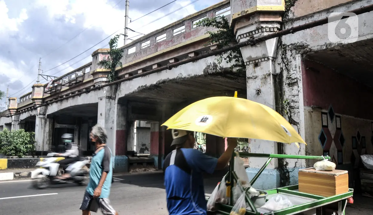 Warga melintas di bawah Jembatan Kereta Matraman, Jakarta Timur, Senin (10/1/2022). Jembatan Kereta Matraman menjadi satu dari 14 objek yang ditetapkan sebagai cagar budaya oleh Dinas Kebudayan DKI Jakarta. (merdeka.com/Iqbal S. Nugroho)