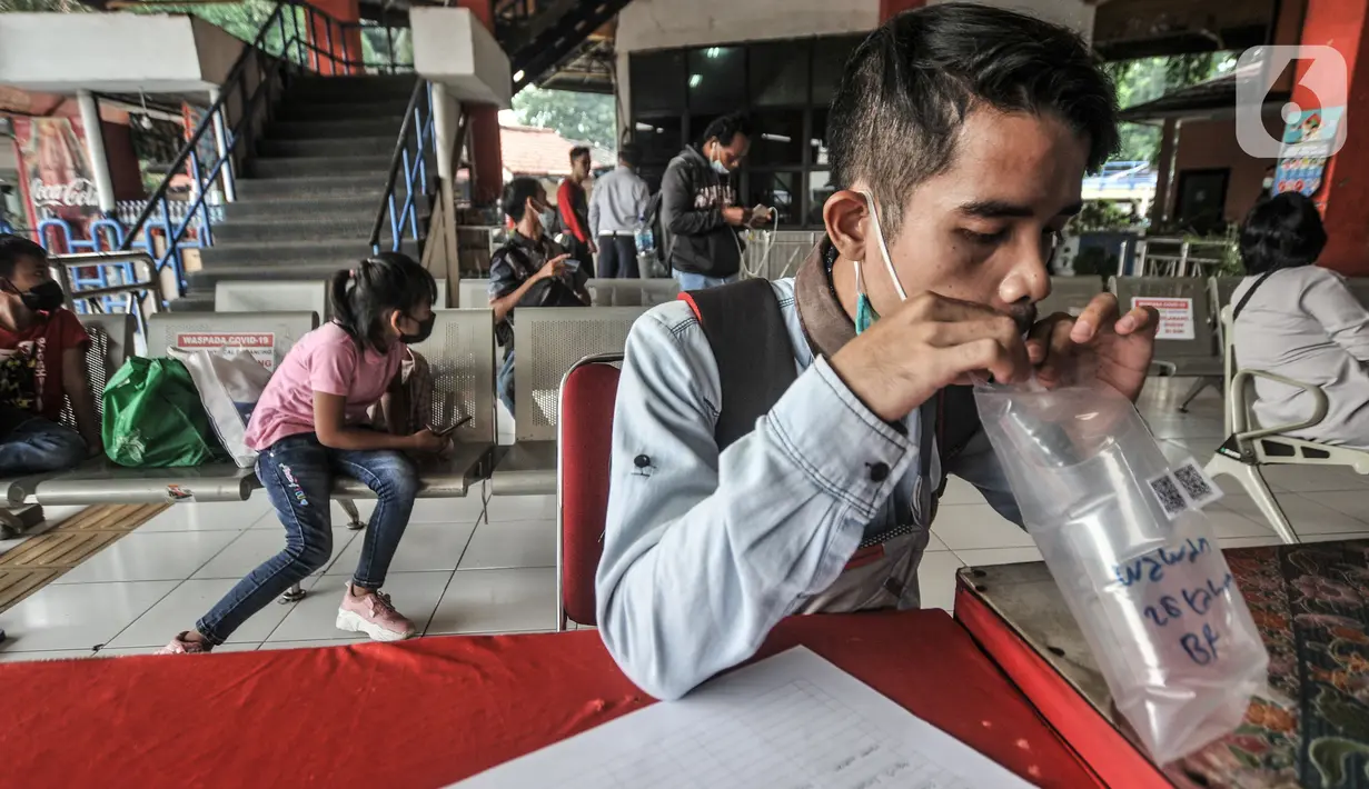 Pemudik meniup kantong saat dites dengan GeNose C19 di Terminal Kampung Rambutan, Jakarta, Minggu (23/5/2021). Pengelola Terminal Kampung Rambutan memberlakukan tes Genose sebagai syarat wajib bagi para pemudik yang baru tiba guna memutus penyebaran virus Covid-19. (merdeka.com/Iqbal S Nugroho)