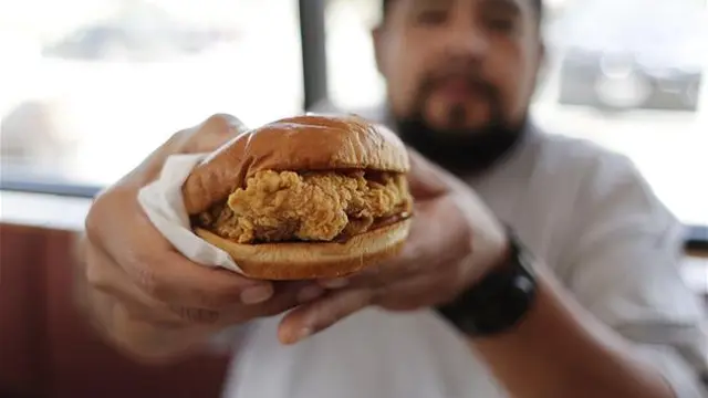 Randy Estrada memegang chicken sandwiche dari restoran Popeyes, 22 Agustus 2019 di Kyle, Texas. (AP/Eric Gay)