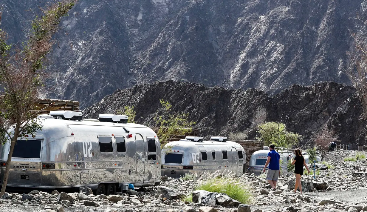 Wisatawan menuju trailer gurun yang berada di lokasi glamping atau glamorous camping di Hatta, Dubai, 15 Februari 2019. Glamping memberikan kemudahan bagi orang-orang ingin liburan ala kemping, namun lebih mewah. (Karim Sahib/AFP)