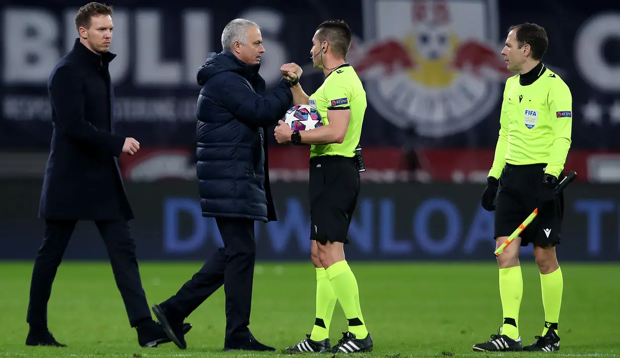 Pelatih Tottenham Hotspur, Jose Mourinho dan Wasit asal Spanyol Carlos del Cerro Grande  melakukan "Elbow bump" usai pertandingan melawan RB Leipzig pada leg kedua babak 16 besar Liga Champions di Red Bull Arena, Jerman (10/3/2020). (AFP/Ronny Hartmann)