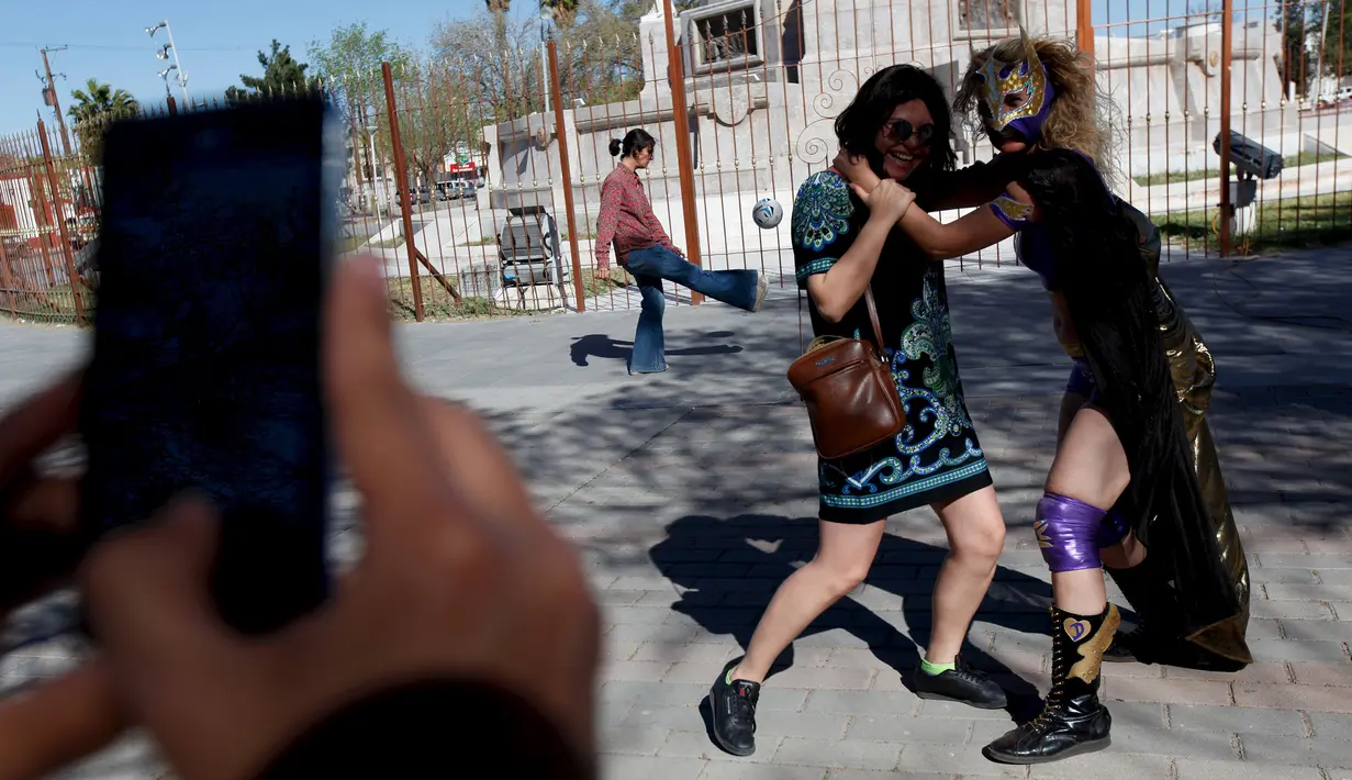 Pegulat Jerman 'Diosa del Rhin' (Dewi Rhin) berpose dengan seorang warga saat aksi kesetaraan gender di Ciudad Juarez, Meksiko (13/3/2016). Selain pegulat, Rhin juga merupakan seorang aktivis perempuan. (Reuters/Jose Luis Gonzalez)