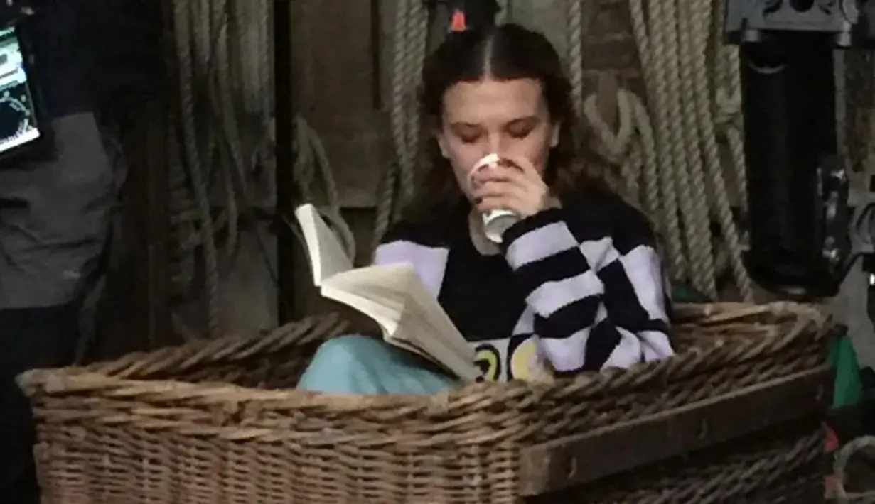 Millie Bobby Brown pun turut mengunggah berbagai momen disela-sela waktu syutingnya pada akun Instagram. Dirinya juga terlihat begitu santai menunggu giliran syuting sembari membaca buku. (Liputan6.com/IG/@milliebobbybrown)