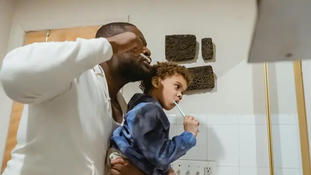 Orangtua sedang menyikat gigi bersama anak