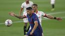 Striker Atletico Madrid, Luis Suarez, berebut bola dengan pemain Sevilla, Diego Carlos, pada laga Liga Spanyol di Stadion Ramon Sanchez-Pizjuan, Minggu (4/4/2021). Sevilla menang dengan skor 1-0. (AP Photo/Angel Fernandez)