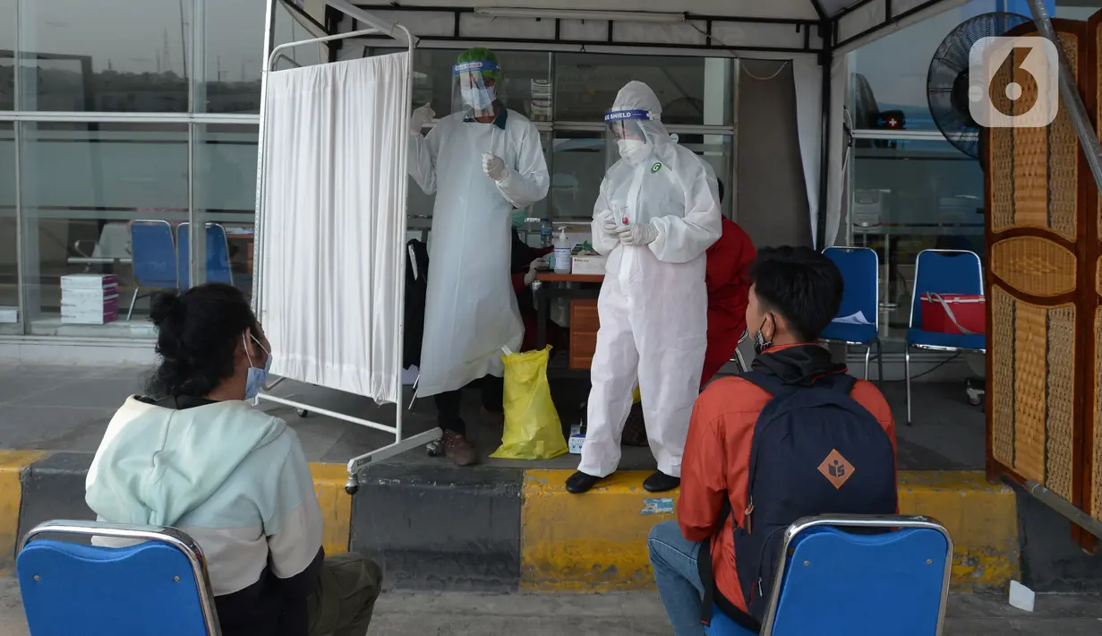 Petugas saat melakukan swab test antigen kepada para pemudik saat arus balik Lebaran di Terminal Pulogebang, Jakarta, Jumat (21/5/2021). Satu minggu setelah Lebaran, pemudik yang tiba di Terminal Pulogebang wajib menjalani tes COVID-19. (merdeka.com/Imam Buhori)