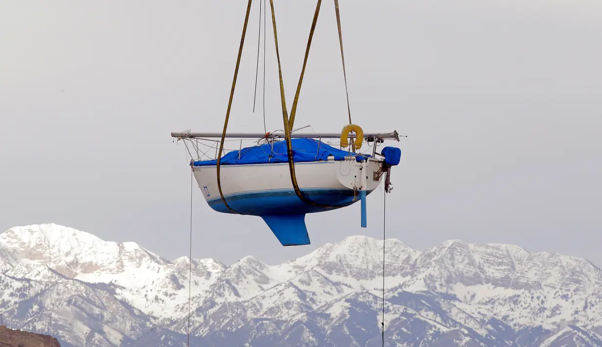 Sebuah perahu layar diangkat untuk dipindahkan ke Great Salt Lake, Utah (6/4). Sebelumnya perahu ini selama dua tahun tidak digunakan karena pantai Utah dilanda kekeringan. (AP Photo / Rick Bowmer)