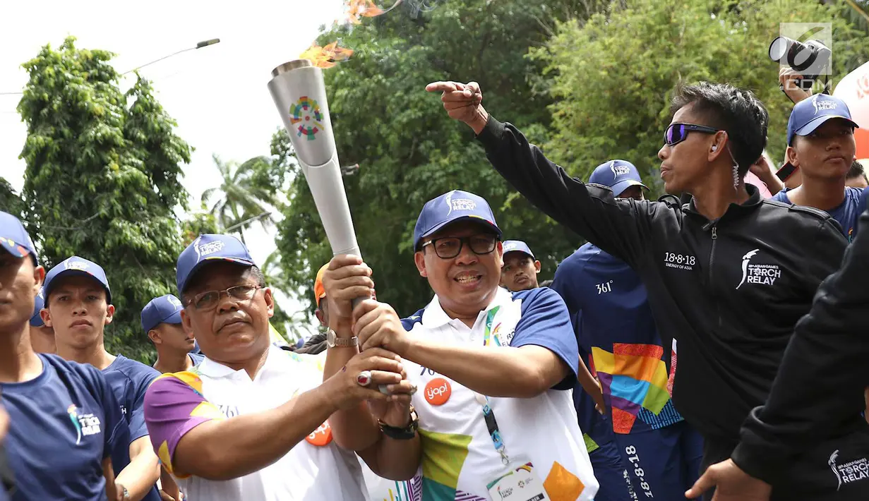 Wali Kota Banda Aceh Aminullah Usman (kiri), saat kirab Obor (torch relay) Asian Games di Banda Aceh, Selasa (31/7). Kirab Obor dimulai dari Museum Aceh dan berakhir di Kantor Gubernur Aceh. (Liputan6.com/Immanuel Antonius)