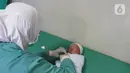 Perawat merawat bayi yang baru lahir di Rumah Sakit Ibu dan Anak Tambak, Jakarta, Kamis (20/2/2020). Bayi laki-laki yang belum diberi nama dari pasangan Khaidah Nurmayanti dan Agus Suseno itu lahir pada tanggal 20 bulan 02 tahun 2020 atau 20-02-2020. (Liputan6.com/Herman Zakharia)