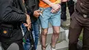 Sebelumnya, polisi menangkap ketiga tersangka yang merupakan warga negara Australia terkait kasus penembakan di sebuah vila di Munggu, Badung, Bali, pada 14 Juni 2025. Tampak dalam foto, tersangka Darcy Francesco Jenson (tengah) dibawa kembali ke rumah tahanan setelah menjalani pemeriksaan oleh pihak kejaksaan di Badung, Bali, pada 15 Oktober 2025. (Dicky Bisinglasi/AFP)