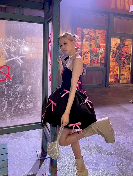 Dres hitam tanpa lengan dengan detail pita pink yang digunakan Rose dalam salah satu video klip solonya ini juga tak lepas dari perhatian netizen. Ia pun tampak begitu anggun dengan simpel dress hitam dan sepatu serta tas warna senada. (Liputan6.com/IG/@roses_are_rosie)