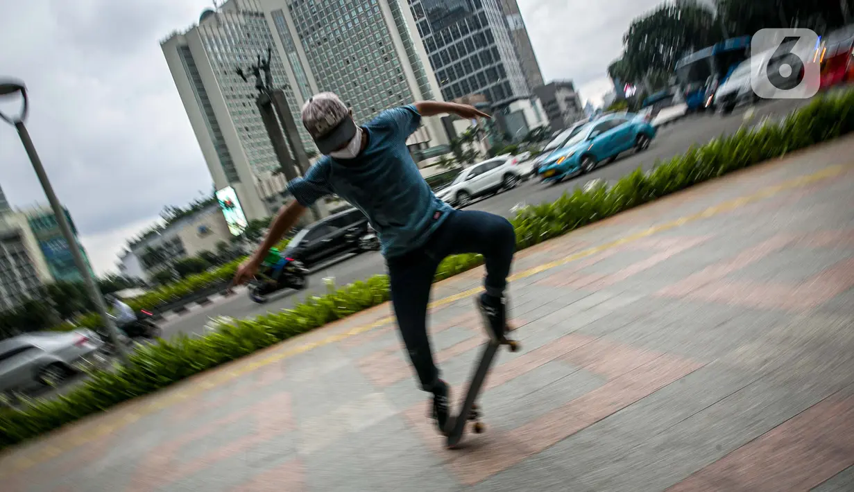 AKsi warga saat bermain skateboard di trotoar Jalan Sudirman-Thamrin, Jakarta, Jumat (5/3/2021). Gubernur DKI Jakarta Anies Baswedan mengizinkan trotoar untuk digunakan sebagai tempat bermain skateboard dengan beberapa kesepakatan. (Liputan6.com/Faizal Fanani)