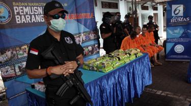 Petugas BNN menjaga barang bukti narkoba sebelum dimusnahkan di lapangan parkir BNN, Jakarta Timur, Jumat (26/1). BNN memusnahkan 40 kilogram sabu hasil penangkapan dari jaringan Penang Malaysia pada 10 Januari 2018 lalu. (Liputan6.com/Arya Manggala)