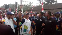 Kapolres Garut AKBP Budi Satria Wiguna, saat menerima obor Asian Games di Garut beberapa waktu lalu. (LIputan6.com/Jayadi Supriadin)