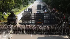 Ratusan petugas berjajar menutup Jalan Medan Merdeka Barat, Senin (1/5). Aksi perayaan Hari Buruh Internasional oleh ribuan buruh tertahan di depan Kementerian Pariwisata akibat penutupan Jalan medan Merdeka Barat. (Liputan6.com/Helmi Fithriansyah)