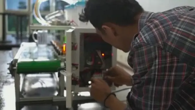 Mahasiswa Politeknik Caltex Riau memperlihatkan cara kerja mesin pencampur minuman otomatis ciptaannya.