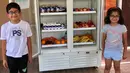 Dua orang anak berpose di depan kulkas yang berisi makanan dan minuman jelang bulan Ramadan di Dubai. Di Dubai setiap bulan Ramadan warga dan donatur mengisi kulkas yang berisi makanan dan minuman untuk berbuka puasa. (www.instagram.com/ramadanfridgesdxb)