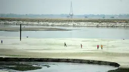 Sejumlah anak bermain di dekat sungai yang kering di Allahabad, India (3/6/2015). Cuaca panas yang melanda India tidak hanya menewaskan ratusan warga, tetapi mengubah sungai menjadi seperti lapangan.  (AFP PHOTO/SANJAY Kanojia) 