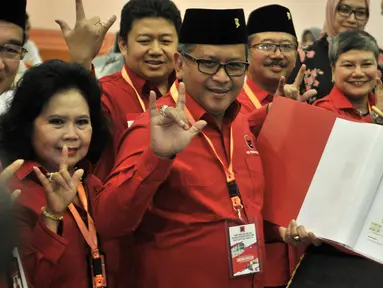 Sekjen PDIP Hasto Kristiyanto (tengah) menunjukkan daftar bakal caleg ke KPU di Jakarta, Selasa (17/7). Hasto tampak beberapa kali mengacungkan salam metal. (Merdeka.com/Iqbal Nugroho)