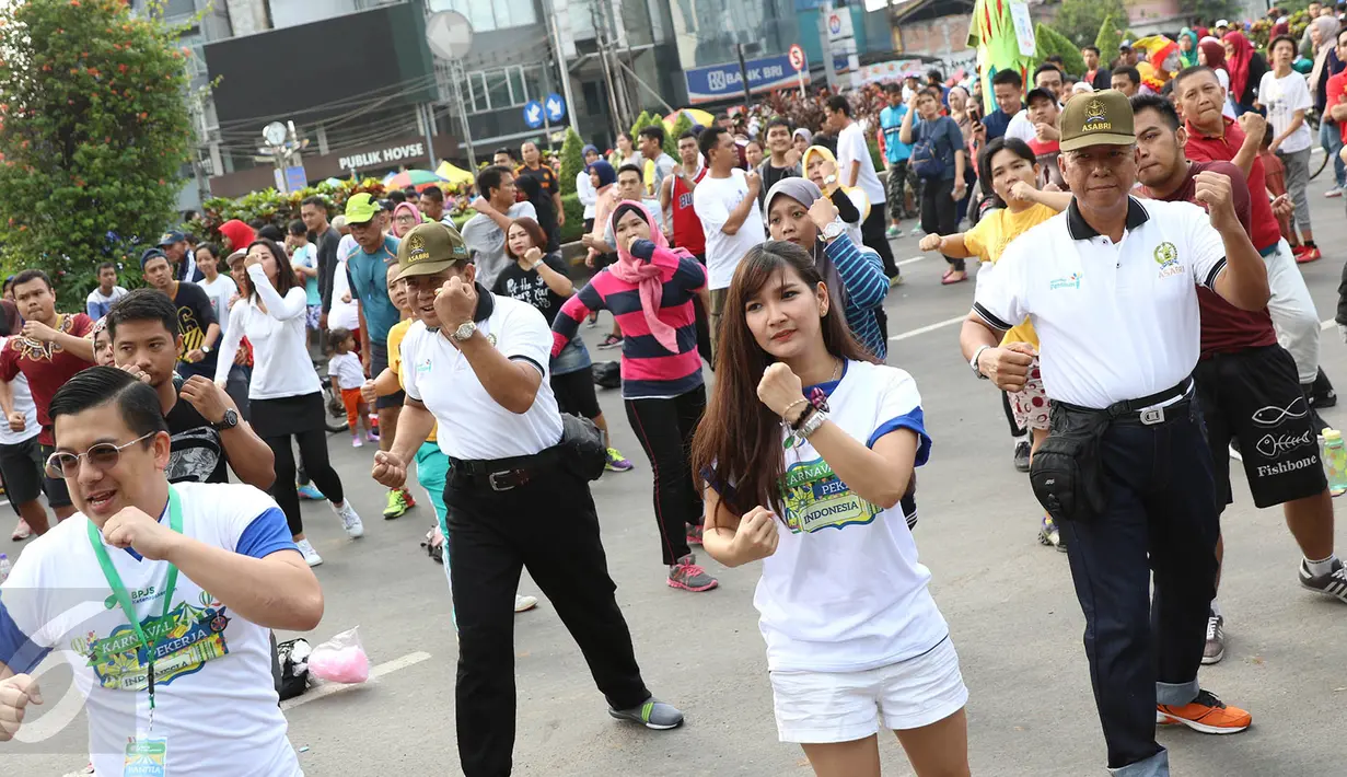 Peserta mengikuti kegiatan body combat dalam acara sosialisasi bertajuk karnaval pekerja di area Car Free Day (CFD) Jalan Jenderal Sudirman, Jakarta Pusat, Minggu (14/5). (Liputan6.com/Immanuel Antonius)