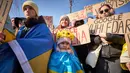 Unjuk rasa menandai tahun keempat sejak dimulainya invasi skala penuh Rusia ke Ukraina yang terjadi pada 24 Februari 2022. Tampak dalam foto, orang-orang memegang spanduk saat anggota komunitas Ukraina menggelar protes untuk menandai tahun keempat sejak dimulainya invasi skala penuh Rusia ke Ukraina di Bukares, Rumania, Minggu 22 Februari 2026. (AP Photo/Vadim Ghirda)