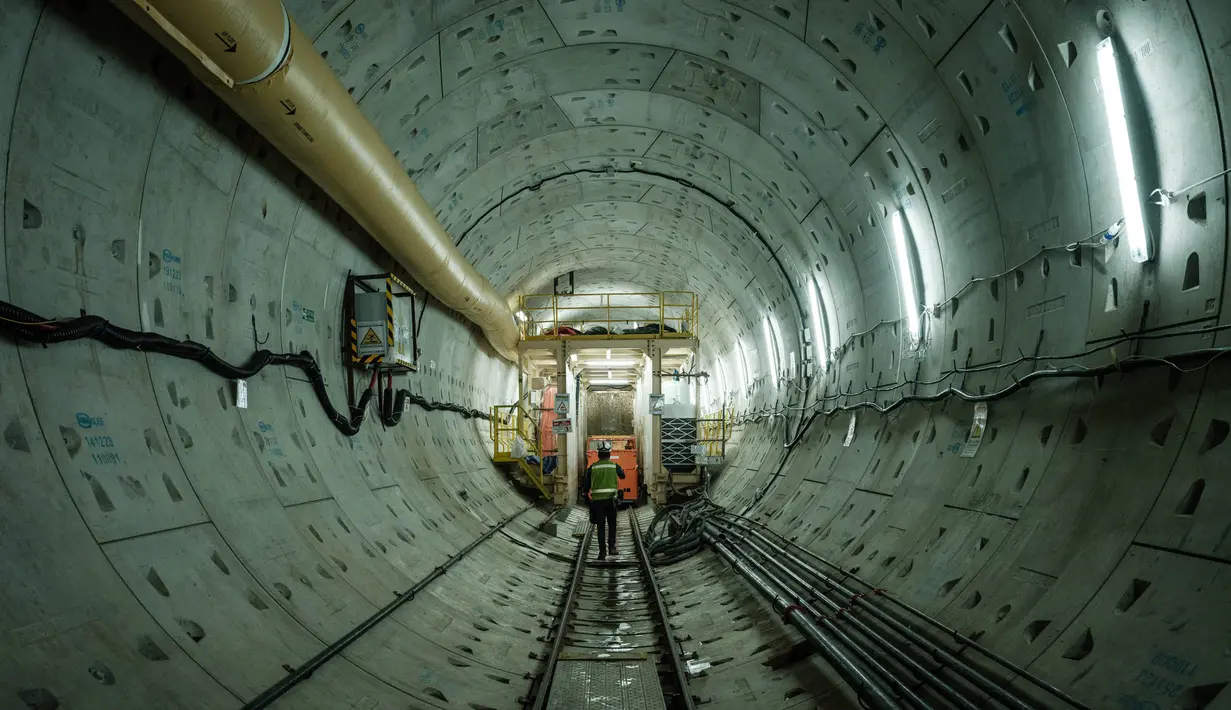 Seorang pekerja berjalan di ujung lokasi pembangunan terowongan dengan mesin bor terowongan untuk proyek Mass Rapid Transit (MRT) Fase 2, yang akan memperpanjang jalur saat ini ke arah utara dengan dana pinjaman dari Japan International Cooperation Agency (JICA), di Jakarta pada tanggal 7 Mei 2024. (Yasuyoshi CHIBA/AFP)