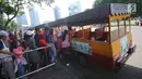 Pengunjung antre naik kereta wisata untuk berkeliling kawasan Monumen Nasional, Jakarta, Senin (25/12). Libur perayaan Natal dimanfaatkan warga untuk berwisata di kawasan Monumen Nasional. (Liputan6.com/Helmi Fithriansyah)