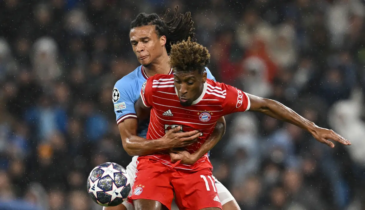 Pemain Bayern Munchen, Kingsley Coman (kanan) berebut bola dengan pemain Manchester City, Nathan Ake pada laga leg pertama perempat final Liga Champions 2022/2023 di Etihad Stadium, Manchester, Rabu (12/04/2023) WIB. Coman minim memberi kontribusi bagi lini serang Bayern. Ia terlihat tidak efektif berada di sisi kanan dan kesulitan menghadapi tantangan dari Nathan Ake. (AFP/Paul Ellis)