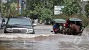 Hujan yang mengguyur Jakarta sejak Minggu (8/2) lalu, mengakibatkan tingginya genangan air di kawasan Kelapa Gading. Tampak mobil dan delman berusaha menerobos banjir, Jakarta, Selasa (10/2/2015). (Liputan6.com/Faizal Fanani)