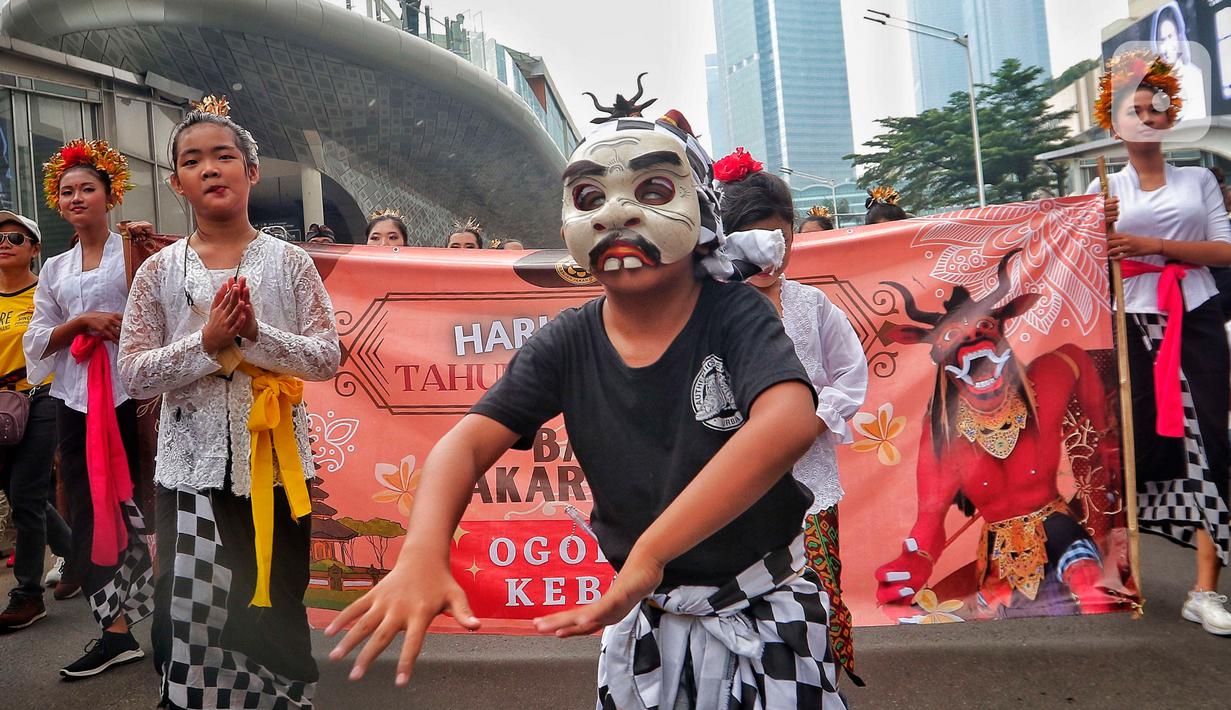 Penari saat mengarak ogoh-ogoh saat hari bebas berkendara di kawasan Bundaran HI, Jakarta, Minggu (12/3/2023). Ogoh-ogoh sendiri dalam kebudayaan Bali biasa menggambarkan kepribadian Bhuta Kala yang dalam ajaran Hindu Dharma merupakan kekuatan (Bhu) alam semesta dan waktu (Kala) yang tak terukur dan tak terbantahkan. (Liputan6.com/Angga Yuniar)