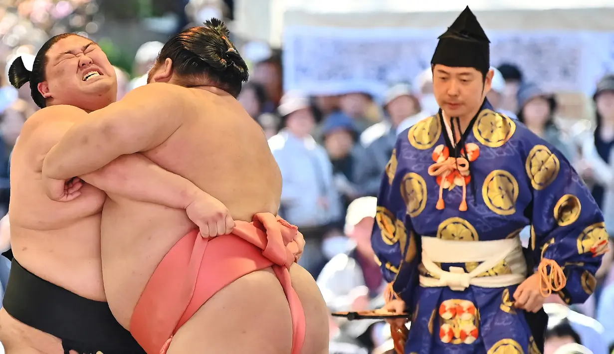 Pegulat sumo bertanding dalam turnamen Honozumo di Kuil Yasukuni, Tokyo, Jepang, 15 April 2019. Honozumo sudah digelar sejak seabad lalu. (TRIBALLEAU CHARLY/AFP)