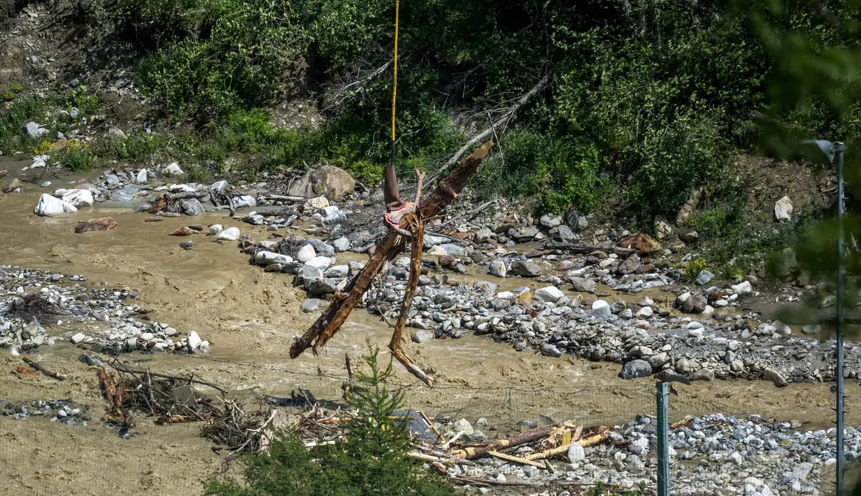 Reruntuhan menjatuhkan jutaan meter kubik es, lumpur, dan longsoran batu serta potongan kayu pohon Cemara yang menghantam desa Blatten yang berada tepat di bawah lembah. (Fabrice COFFRINI/AFP)
