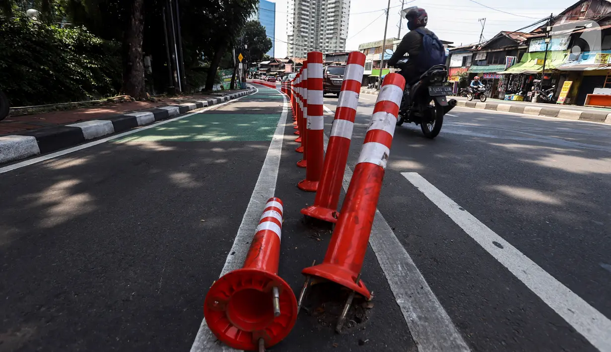 Pengendara melintasi "stick cone" pembatas jalur sepeda di kawasan Pejompongan, Jakarta, Selasa (29/11/2022). Pemprov DKI Jakarta kembali mengganggarkan dana untuk perawatan jalur pembatas sepeda pada rancangan APBD tahun anggaran 2023 sebesar Rp7,5 miliar setelah sebelumnya sempat dicoret dari anggaran dan menuai kecaman dari sejumlah pihak. (Liputan6.com/Johan Tallo)