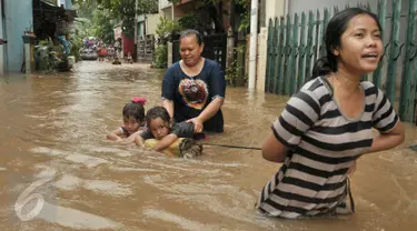 Warga melintasi banjir di kawasan Cipinang Melayu, Jakarta Timur, Senin (20/2). Banjir ini merendam RW 3 hingga RW 4, Kelurahan Cipinang Melayu, Kecamatan Cipinang Muara. (Liputan6.com/Yoppy Renato)