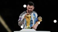 Pemain ArgentinaLionel Messi memegang trofi penghargaan Bola Emas saat membelai trofi Piala Dunia 2022 usai melawan Prancis pada pertandingan sepak bola final Piala Dunia 2022 di Stadion Lusail, Lusail, Qatar, 18 Desember, 2022. Lionel Messi dinobatkan sebagai peraih Bola Emas atau Golden Ball sebagai perlambang pemain terbaik selama Piala Dunia 2022 setelah memimpin Argentina menaklukkan Prancis dalam babak final. (AP Photo/Martin Meissner)