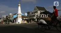Pengemudi becak melintas di perempatan Tugu Pal Putih Yogyakarta, Sabtu (26/12/2020). Tugu yang dulunya bernama tugu Golong Gilig ini memiliki sejarah panjang dan menjadi salah satu keistimewaan kota Yogya ini terlihat rapi dan ramai dikunjungi wisatawan. (Liputan6.com/Helmi Fithriansyah)